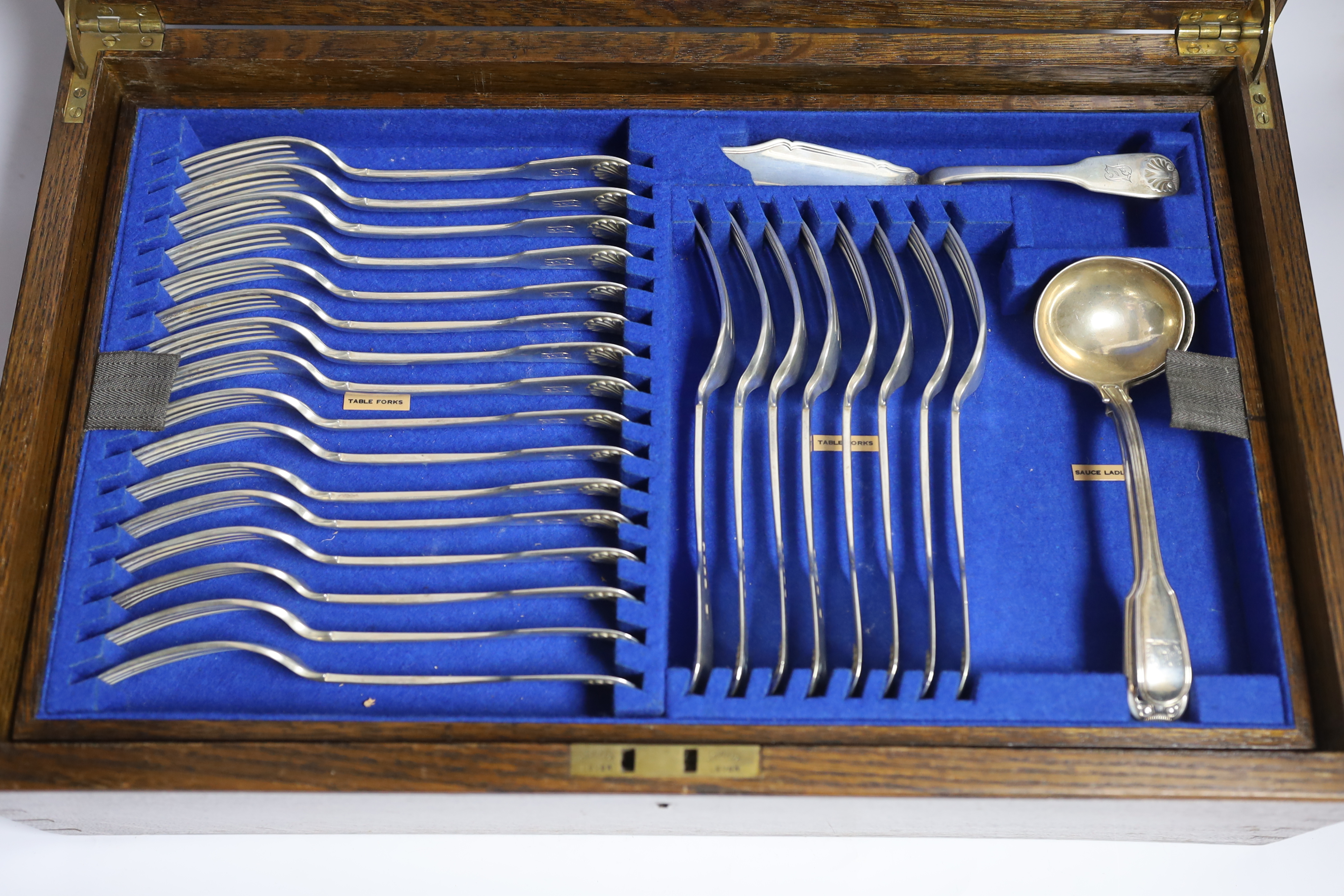 A Victorian oak cased matched canteen of silver fiddle and shell pattern flatware, by John & Henry Lias & H.J. Lias & Son